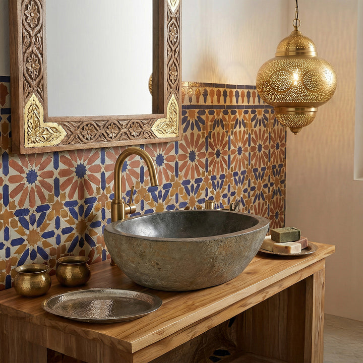 River stone Washbasin in the oriental bathroom on a wooden console, combined with brass fittings, mosaic tiles and warm light