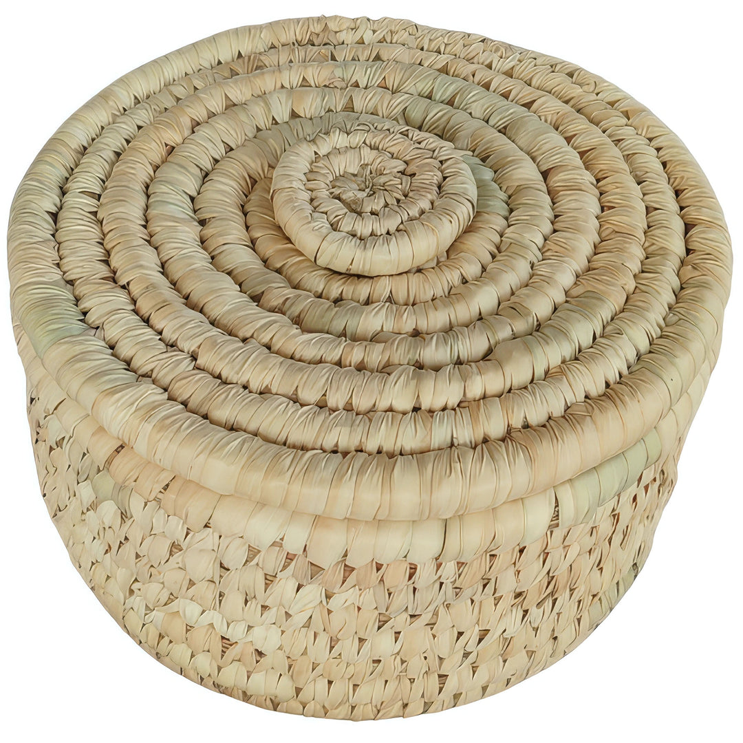 Small round palm leaf basket with closed lid, spiral weave and pale beige and straw tones.