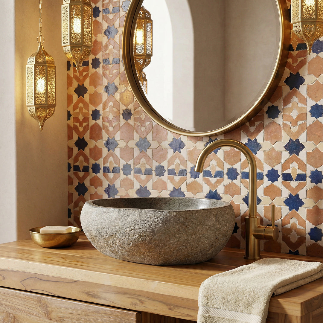 Countertop washbasin made of natural stone on a wooden console, combined with brass fittings and oriental tiles