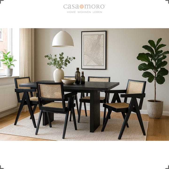 Elegant dining room with black armchairs made of teak and Viennese wicker, harmoniously combined with a dark dining table