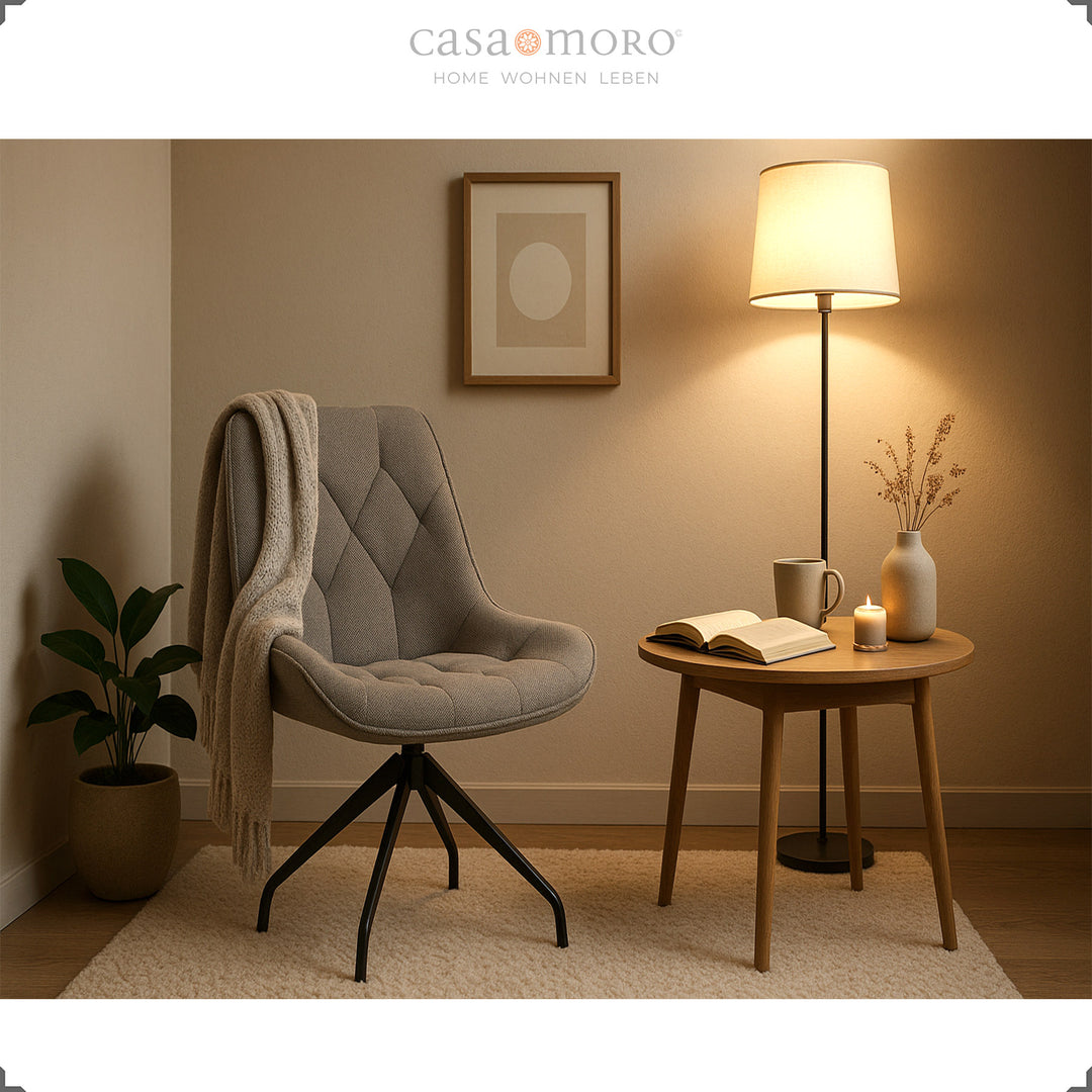 Gray dining chair with 360° swivel function and black metal frame - cozy reading corner with side table, blanket and warm light