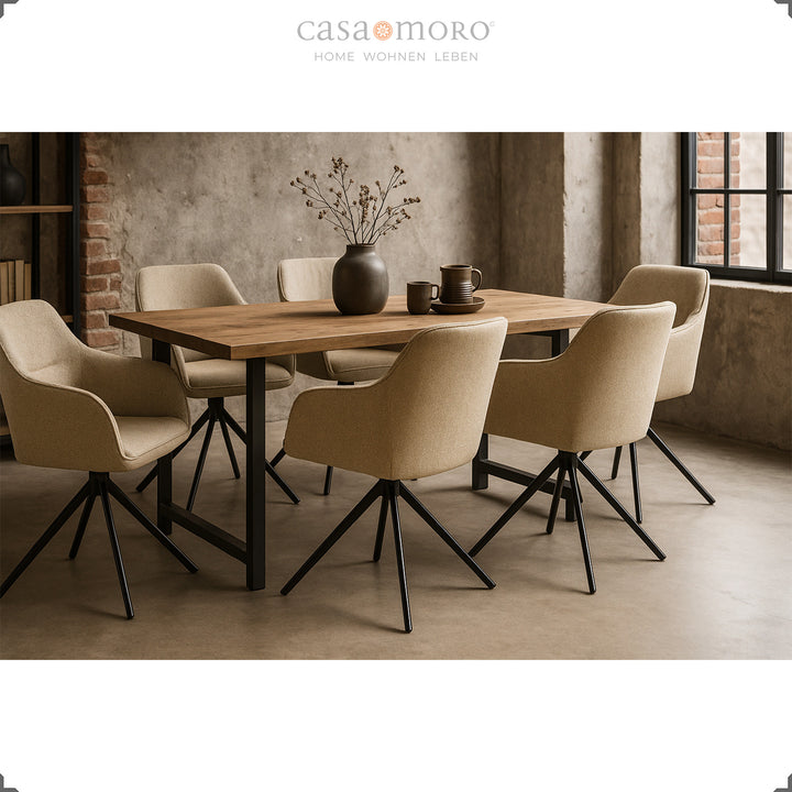 Six 360° swivel upholstered chairs with beige armrests around a wooden table in a modern dining room with concrete walls and a black metal frame