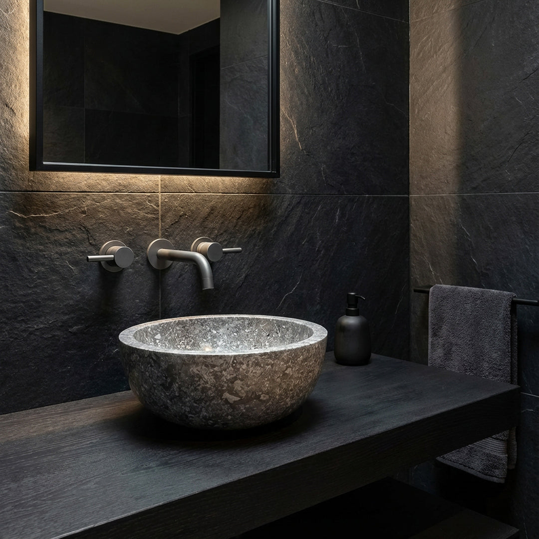 Round Washbasin made of dark natural stone as an attachment on a black console in a modern, minimalist bathroom ambience