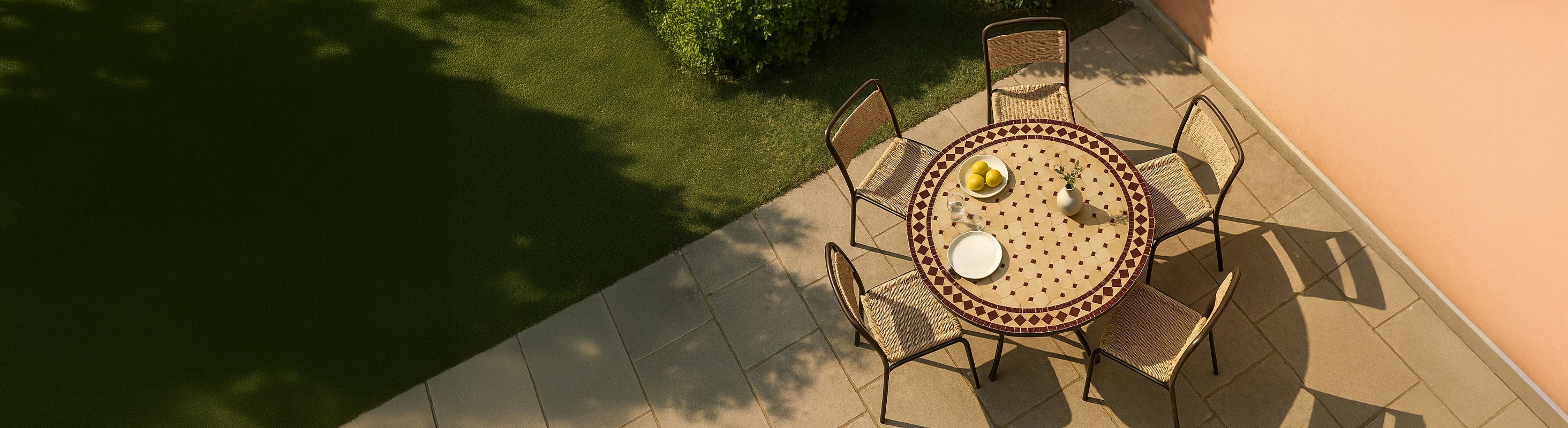 Mosaic tables Ø100 – Large round mosaic table Ø100 cm with zellige tiles and several chairs on the terrace in the garden from a bird's eye view with warm sun