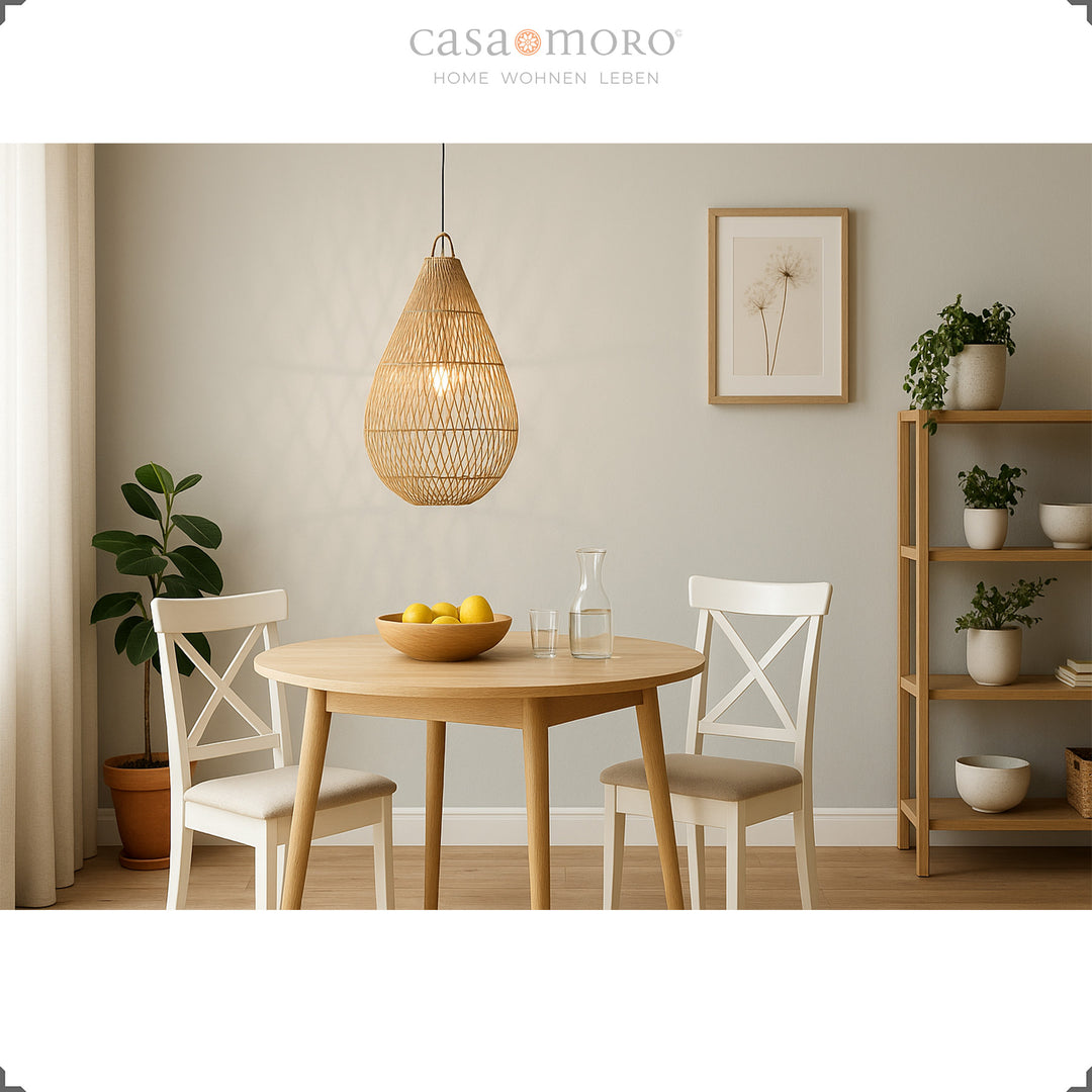 Handmade teardrop-shaped rattan lamp above a dining table, providing warm light and creating a cozy atmosphere