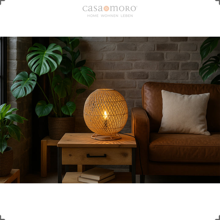 Round rattan bedside lamp on side table next to leather sofa, warm light and natural