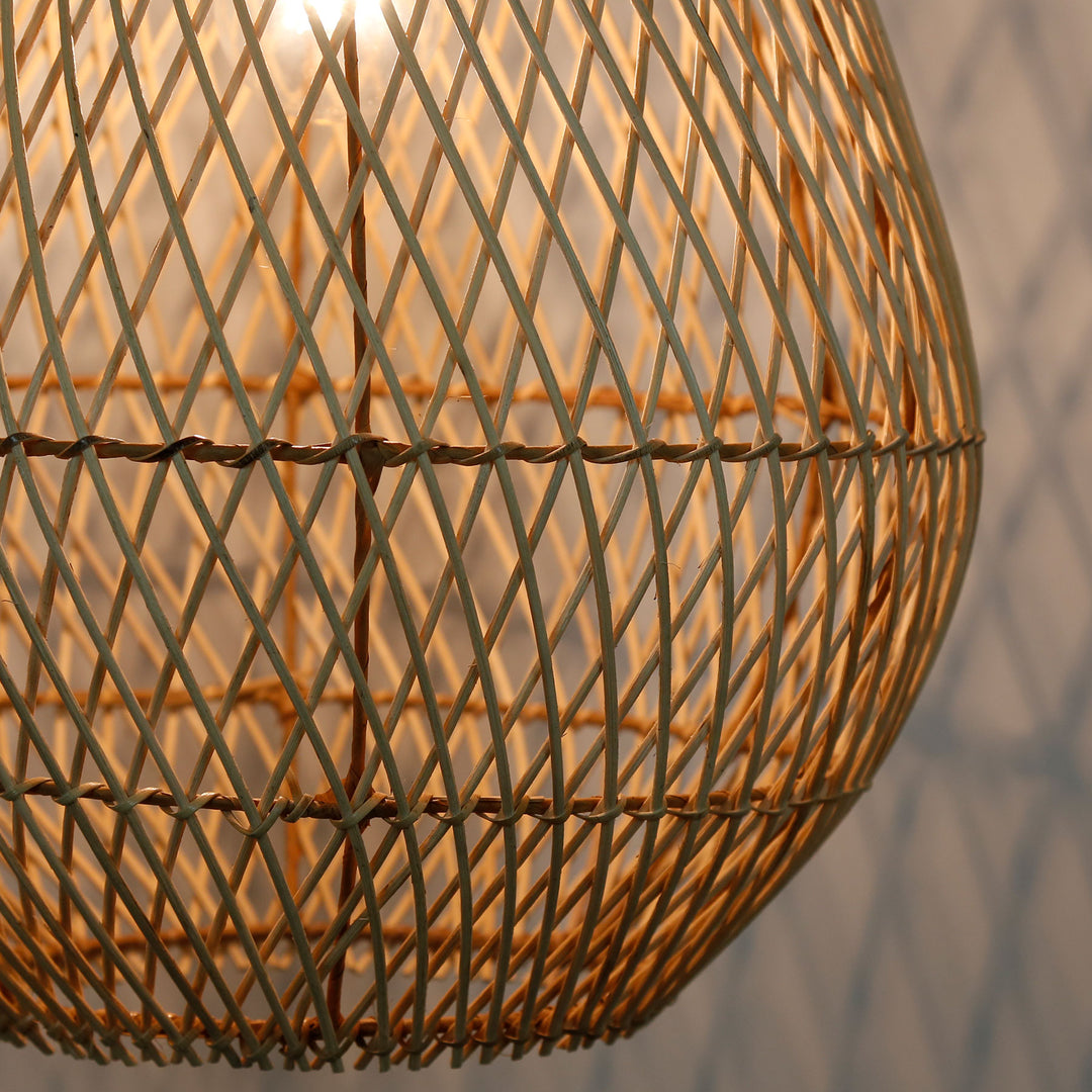 Detailed shot of a handmade rattan lamp with a fine, diagonal weave pattern and warm light