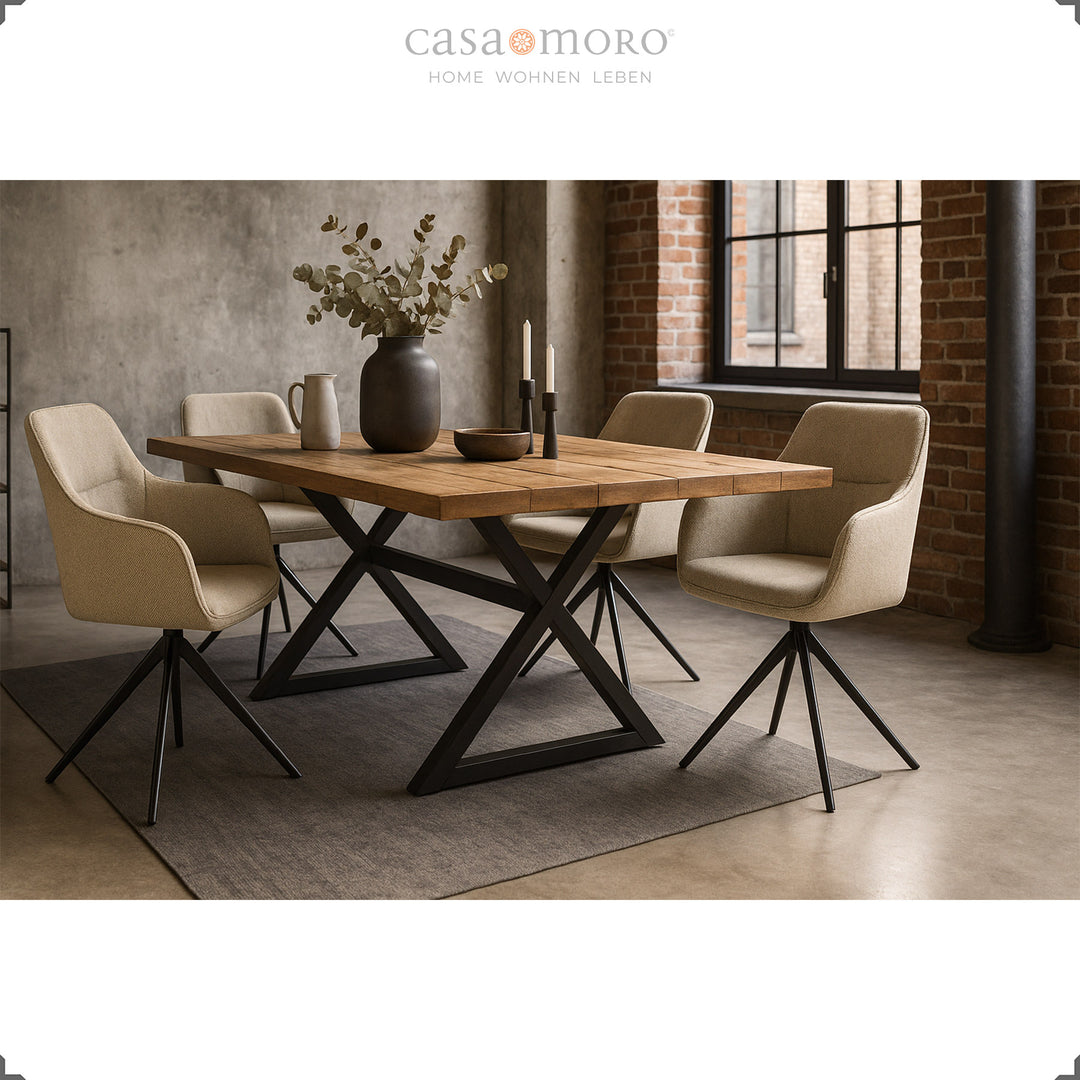Four 360° swivel upholstered chairs with beige armrests at a wooden table with a black metal frame in a modern dining room with a brick wall