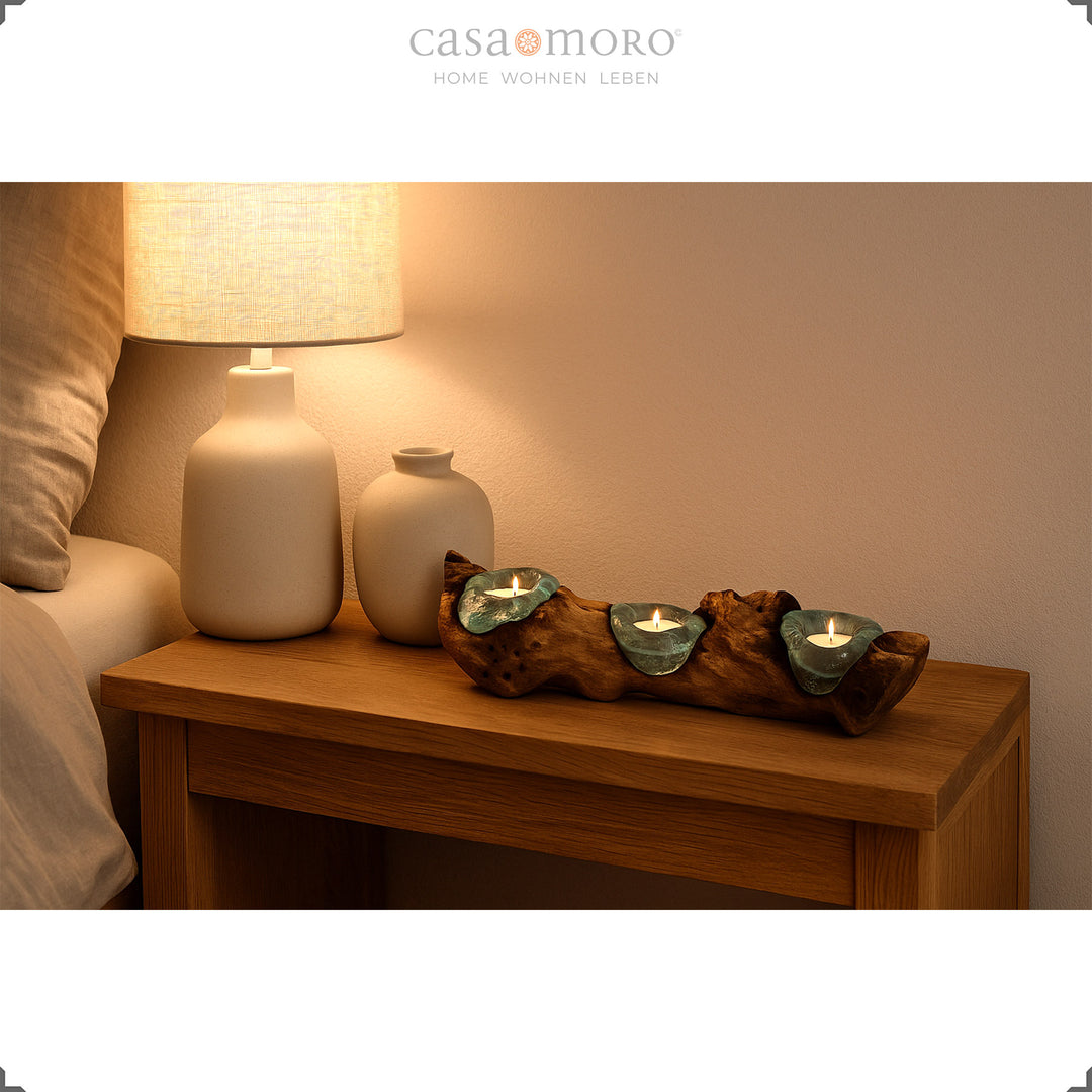 Elongated 3 tea light holder made of glass and burl wood on a bedside table, its soft light creates a calming bedroom atmosphere.