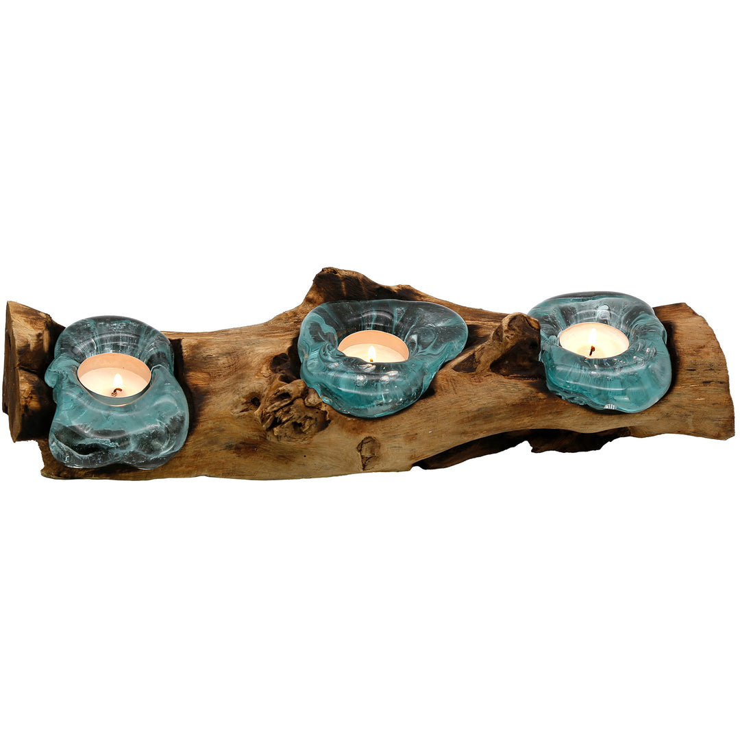 Elongated 3-piece tea light holder made of glass and root wood, each glass shape is unique and together creates a warm, glowing light arrangement.