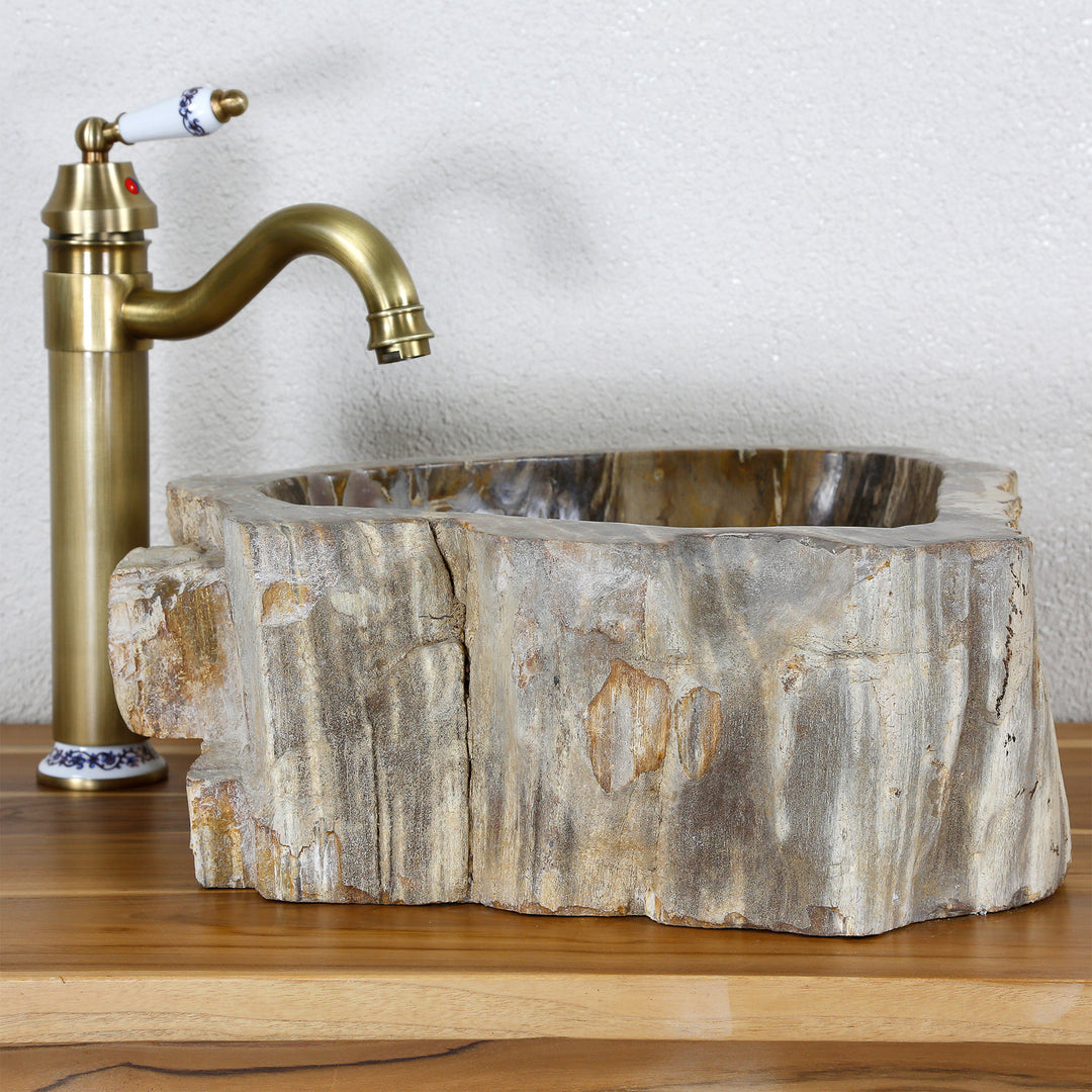 Natural stone Washbasin Made of petrified wood with a distinctive fossil structure on a wooden plate, combined with a brass fitting