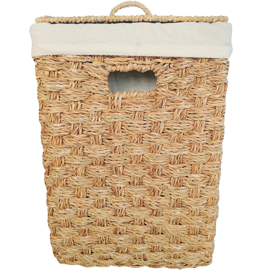 Square laundry basket made of seagrass with a closed lid, a light-colored fabric insert, and a handle opening as seen from the front.