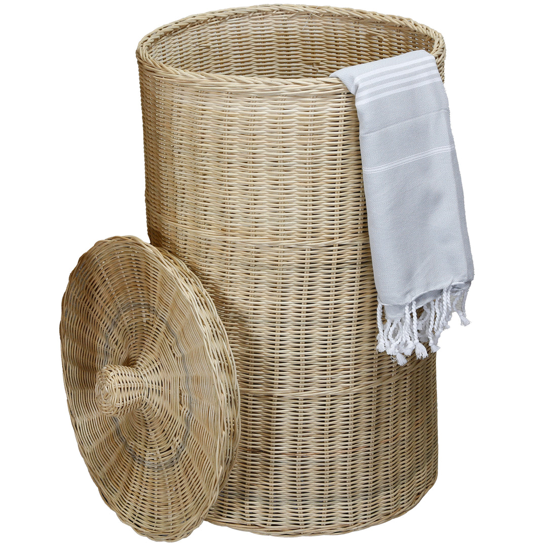 Rattan laundry basket with removable lid, placed in the bedroom, filled with pillows and toiletries