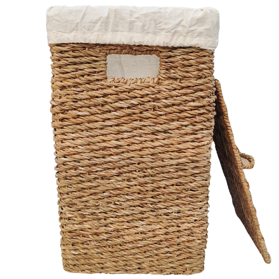 Rectangular laundry basket made of seagrass with a 50-liter capacity, a light-colored fabric insert, and a lid that rests against the side.
