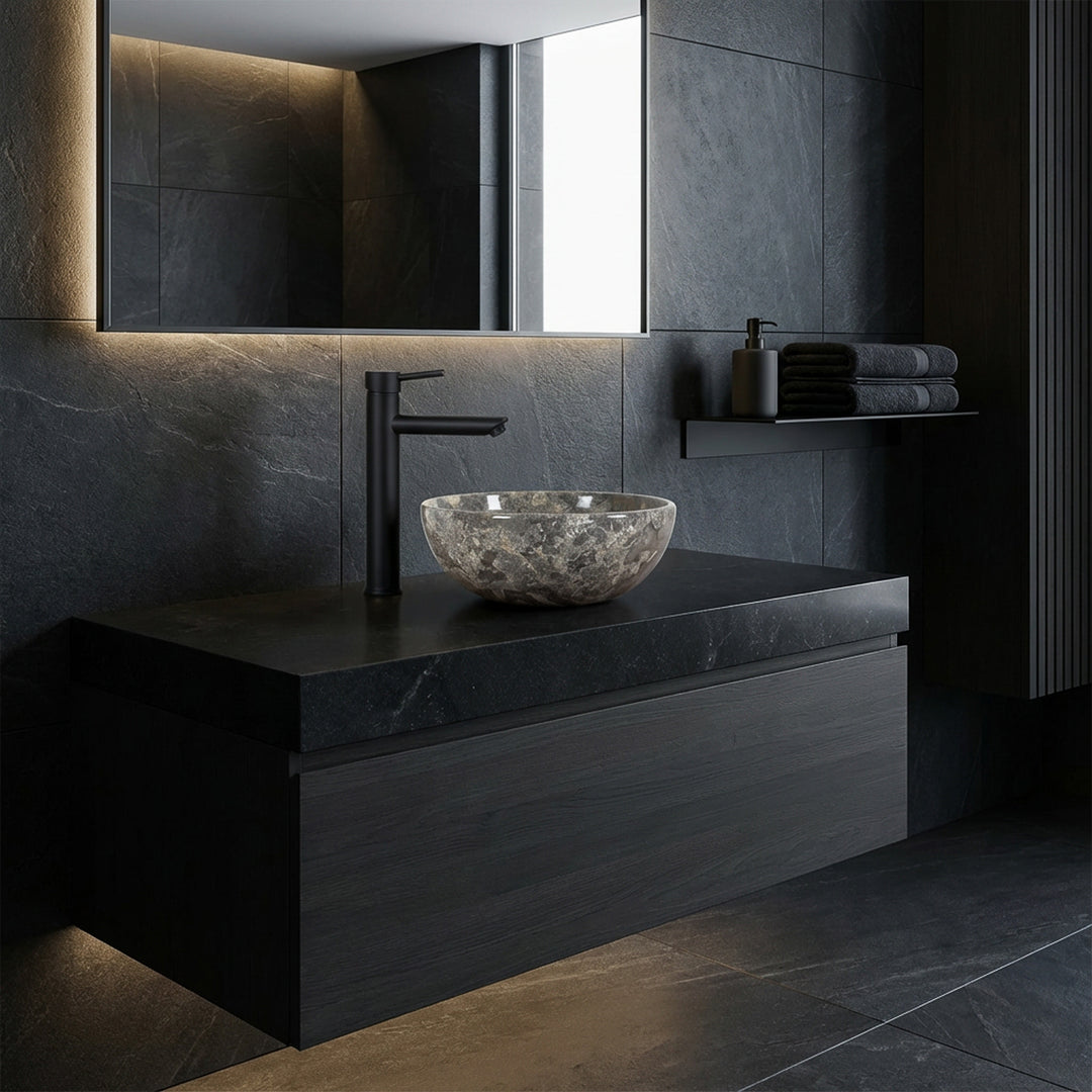 Round natural stone countertop washbasin with gray-brown grain on a dark washbasin in the modern bathroom, combined with black fittings and dark wall design