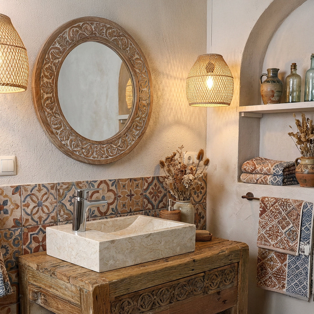 Rectangular countertop washbasin made of light natural stone on a wooden washstand in an oriental bathroom with patterned tiles and warm light